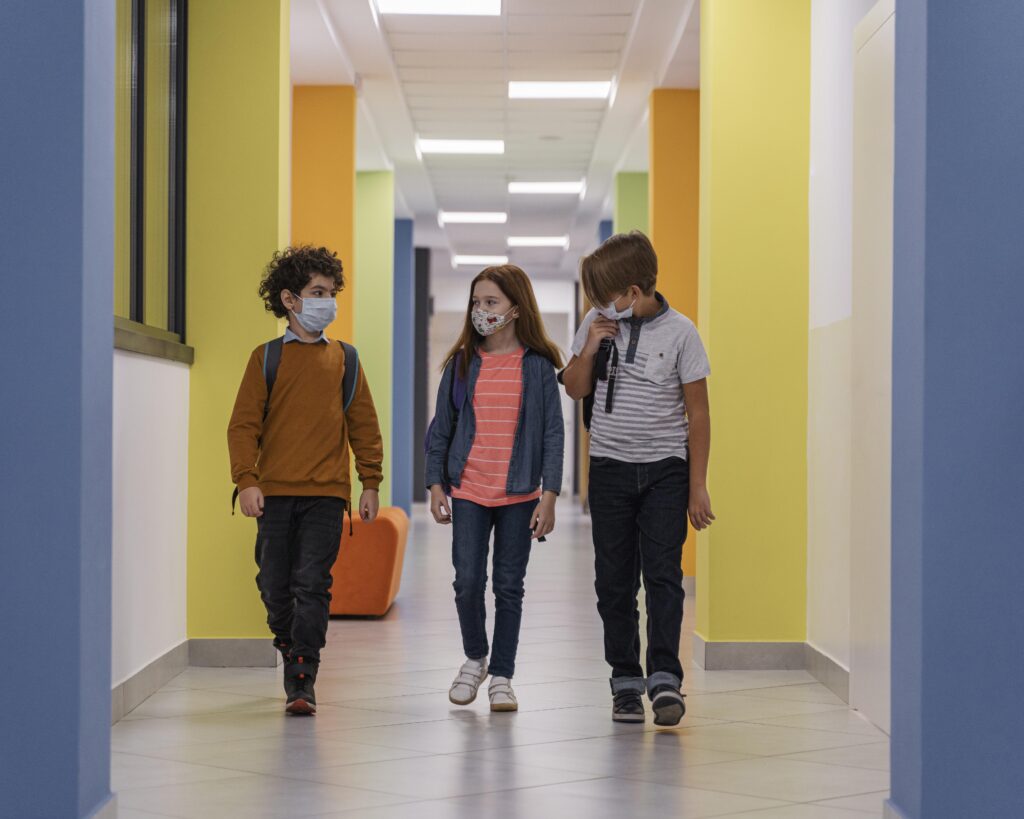 front view children school hallway with medical masks